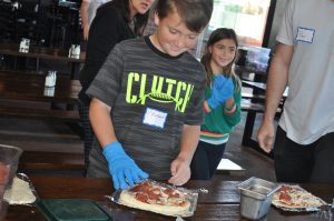 Walk With Sally mentee participates in pizza making at the Friendship Activity with Rock and Brews in Redondo Beach near Los Angeles
