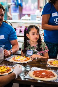 Mentee Barbie making pizza at the Walk With Sally Friendship Activity in Los Angeles