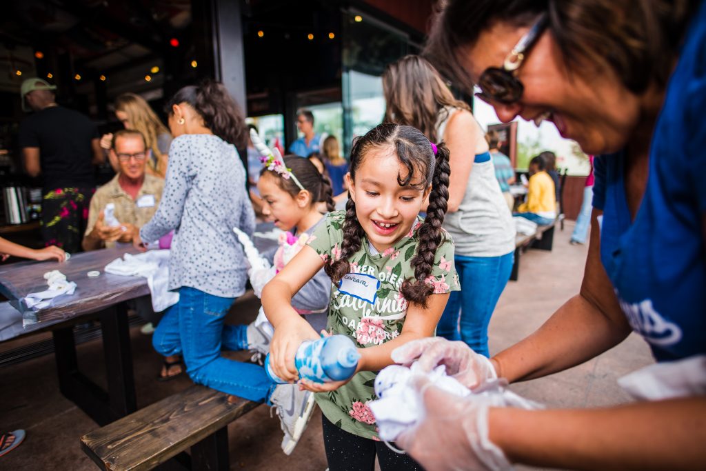 Mentee Barbie tie dying a shirt with her mentor Joanne at Walk With Sally's Friendship Activity in Los Angeles